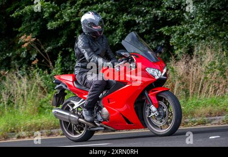 Potterspury, Northants, UK - 11 août 2024 : 2016 Red Honda VFR 800 e moto voyageant sur une route britannique Banque D'Images