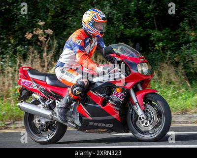 Potterspury, Northants, UK - 11 août 2024 : 1994 moto Suzuki GSXR1100 voyageant sur une route britannique Banque D'Images