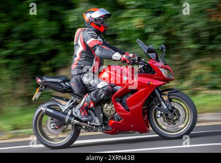 Potterspury, Northants, UK - 11 août 2024 : 2010 moto Yamaha FZS1000 rouge voyageant sur une route britannique Banque D'Images