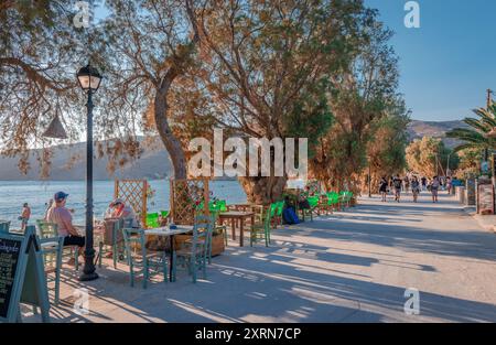 La principale rue piétonne en bord de mer avec des arbres tamarix et des tavernes à Aegiali, île d'Amorgos, Cyclades, Grèce. Banque D'Images