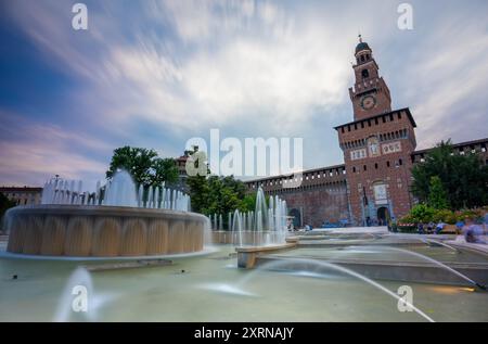 Milan, Italie - 07 juin 2024 : fontaine. La résidence des ducs de Milan de la dynastie Sforza à Milan en arrière-plan. Exposition prolongée. Banque D'Images