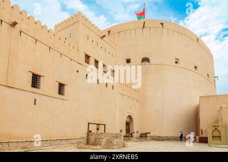 Citadelle arabe forteresse vue de la cour intérieure à la tour principale avec drapeau omanais agitant sur le dessus, Nizwa, sultanat Oman Banque D'Images