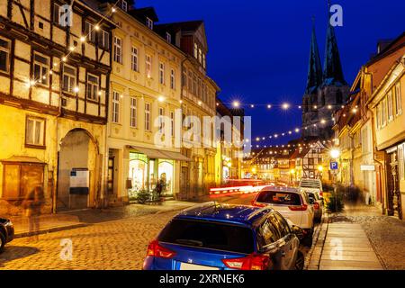 Charmante ville de Quedlinburg soir vue sur la rue illuminée avec des lumières de Noël ancienne église de Nicholas équipée Nicholas Kirche arrière-plan moitié historique Banque D'Images