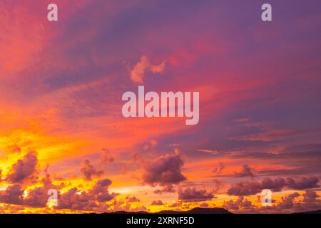 Vue aérienne du ciel coloré au coucher du soleil tandis que des notes d'or rayonnent du coucher du soleil. L'horizon est peint avec un dégradé qui se transforme en teinte douce, Banque D'Images