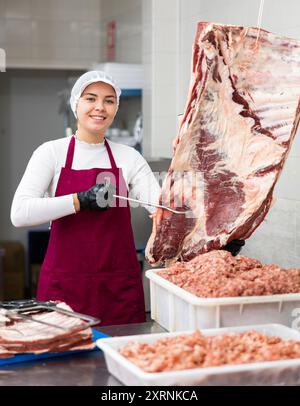 Une jeune femme butcher tenant des côtes de bœuf Banque D'Images