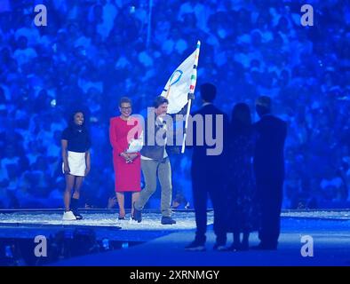 Tom Cruise prend le drapeau olympique de la mairesse de Los Angeles, Karen Bass (au centre) et de l'américaine Simone Biles (à gauche) lors de la cérémonie de clôture des Jeux Olympiques de Paris 2024, au stade de France, à Paris. Date de la photo : dimanche 11 août 2024. Banque D'Images