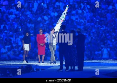 Tom Cruise prend le drapeau olympique de la mairesse de Los Angeles, Karen Bass (au centre) et de l'américaine Simone Biles (à gauche) lors de la cérémonie de clôture des Jeux Olympiques de Paris 2024, au stade de France, à Paris. Date de la photo : dimanche 11 août 2024. Banque D'Images