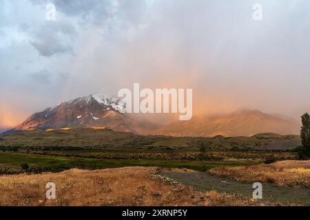 Lever de soleil tôt le matin sur le parc national Torres Del Paine en Patagonie, Chili, mettant en valeur des couleurs spectaculaires et un arc-en-ciel. Banque D'Images