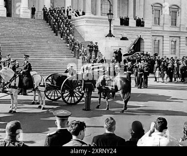 Cercueil drapé de drapeau du défunt président américain John Kennedy transporté par un caisson tiré par des chevaux, arrivant au Capitole des États-Unis après la procession funéraire de la Maison Blanche, l'ancienne première dame des États-Unis Jacqueline Kennedy se tient à droite avec ses enfants, Caroline Kennedy et John F. Kennedy, Jr., Washington, D.C. Abbie Rowe, photographies de la Maison Blanche, 24 novembre 1963 Banque D'Images