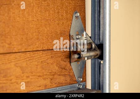 Gros plan de la charnière de porte de garage et du rouleau sur la porte en bois, mise au point sélective. Banque D'Images