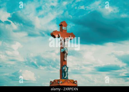 Vieux monument de crucifixion en bord de route contre le ciel dramatique, mise au point sélective Banque D'Images