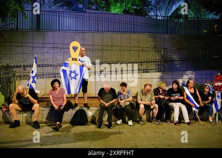 Tel Aviv, Israël. 10 août 2024. Des manifestants israéliens âgés sont assis à côté d'un fil de fer barbelé autour du quartier général de Tsahal pendant le rassemblement. Des milliers d'Israéliens ont manifesté avec les familles des otages contre le premier ministre Benjamin Netanyahu, exigeant un accord immédiat sur les otages et un cessez-le-feu - alors qu'Israël attend l'attaque iranienne et du Hezbollah. Crédit : SOPA images Limited/Alamy Live News Banque D'Images