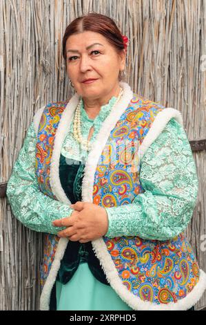 Stanitsa Borgustanskaya, Pyatigorsk, 9 mai 2024. Une vieille belle femme cosaque en vêtements nationaux près de la clôture du hochet. Cour cosaque. Cosaque Banque D'Images