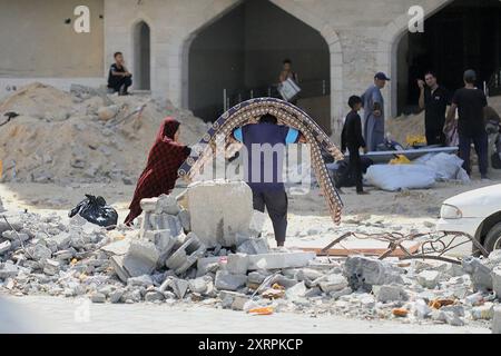 Les Palestiniens vivant dans la région migrent vers le district d'Al Mawasi, la partie ouest de la ville avec leurs biens suite à l'avertissement d'évacuation de l'armée israélienne dans la région de Hamad à Khan Yunis, Gaza, le 11 août 2024. Israël a élargi les ordres d'évacuation à Khan Younis, dans le sud de la bande de Gaza, du jour au lendemain, forçant des dizaines de milliers de résidents palestiniens et de familles déplacées à partir dans l'obscurité alors que les explosions des bombardements de chars se sont répercutées autour d'eux. L’armée israélienne a déclaré qu’elle attaquait des militants du groupe Hamas, qui administrait Gaza avant la guerre, qui utilisaient ces zones Banque D'Images