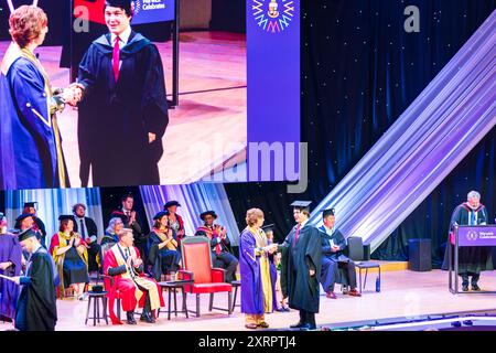 Cérémonie de remise des diplômes au Butterworth Hall, Université de Warwick. Étudiant sur scène pour recueillir son diplôme et se serrer la main avec le président. Banque D'Images