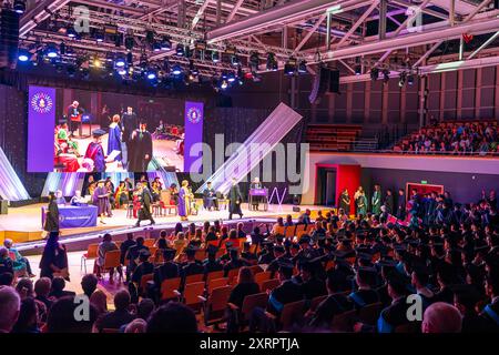 Cérémonie de remise des diplômes tenue au Butterworth Hall de l'Université de Warwick. Les élèves marchent sur scène pour recueillir leurs diplômes avec des applaudissements du public. Banque D'Images