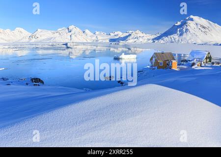 Pittoresque établissement inuit dans un fjord éloigné avec des icebergs et des montagnes, hiver, ensoleillé, Kulusuk, est du Groenland, Groenland Banque D'Images