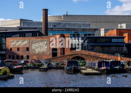 Bateaux de canal et bâtiments en briques dans le quartier historique de Regency Wharf sur l'eau dans le centre-ville de Birmingham en Angleterre par une journée ensoleillée avec un ciel bleu. Banque D'Images