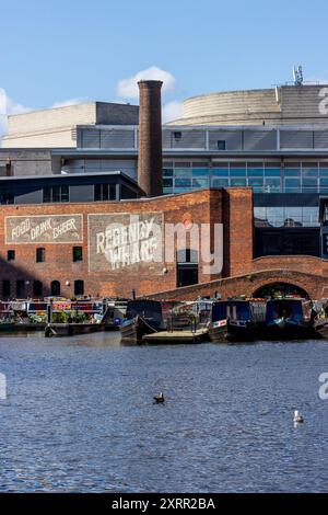 Bateaux de canal et bâtiments en briques dans le quartier historique de Regency Wharf sur l'eau dans le centre-ville de Birmingham en Angleterre par une journée ensoleillée avec un ciel bleu. Banque D'Images