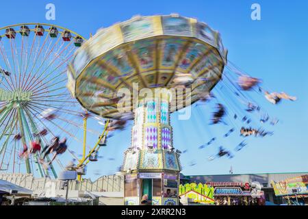 Herne, NRW, Allemagne. 11 août 2024. Un manège traditionnel ou un chairoplane s'avère populaire auprès de la foule. Le dernier jour de Cranger Kirmes, la deuxième plus grande foire funiculaire d'Allemagne, au cœur de la Ruhr, voit des dizaines de milliers de personnes profiter des manèges et des attractions sous un beau soleil chaud avec des températures autour de 30 degrés. La foire a une longue tradition à Herne Crange qui remonte à un marché médiéval et attire environ 4 millions de visiteurs chaque année. Crédit : Imageplotter/Alamy Live News Banque D'Images