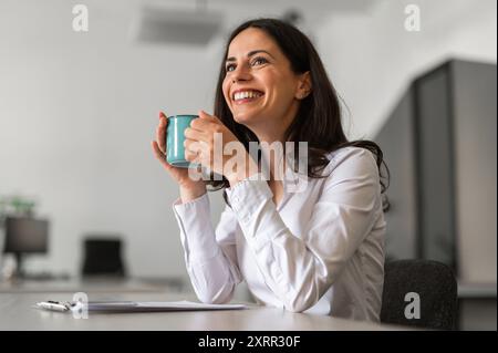 Jeune femme joyeuse et souriante tenant une tasse de café Banque D'Images