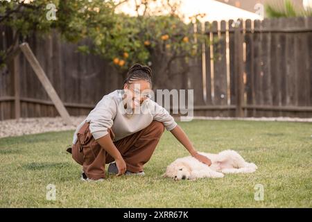 Jeune femme caressant un jeune chiot Banque D'Images