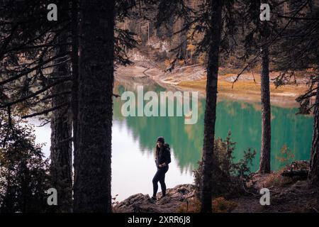 Le randonneur féminin solo profite d'une matinée tranquille au lac Alpine Banque D'Images