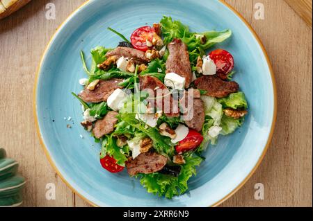 une salade chaude avec de la viande frite et de la sauce. menu du restaurant Banque D'Images