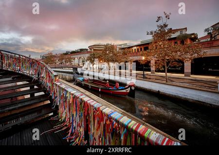 Stadtansicht von Aveiro, genannt das Venedig Portugals, mit bunten Bändern geschmückte Kanalbrücke, Gondel Moliceiro, Nachtansicht mit Himmelsfärbung Impressionen Aveiro *** vue de la ville d'Aveiro, appelé la Venise du Portugal, pont de canal décoré de rubans colorés, gondole Moliceiro, vue de nuit avec la coloration du ciel impressions Aveiro Banque D'Images