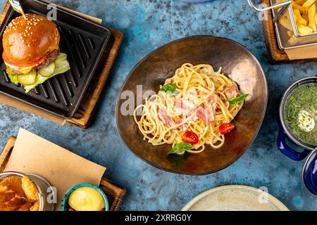 Vue de dessus de spaghetti avec bacon, booger, frites et bouillon. Ensemble de nourriture du menu enfant. Dîner. Service de restaurant Banque D'Images