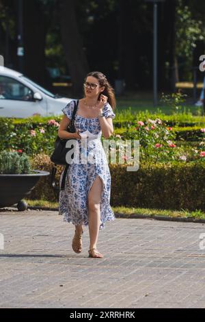 Timisoara, Roumanie - 24 juillet 2024 : femme marchant dans la rue. De vraies personnes. Banque D'Images