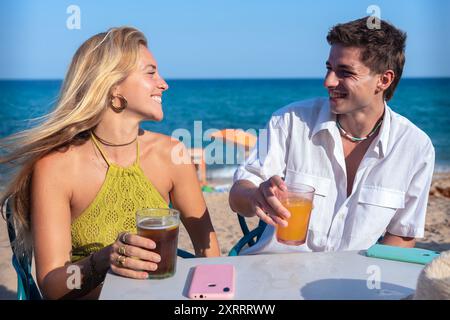 Heureux jeune couple en vacances, boire dans le restaurant. Banque D'Images