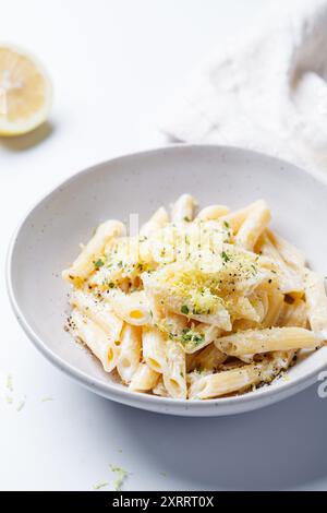 Pâtes crémeuses au citron avec des flocons de Chili dans un bol blanc. Banque D'Images