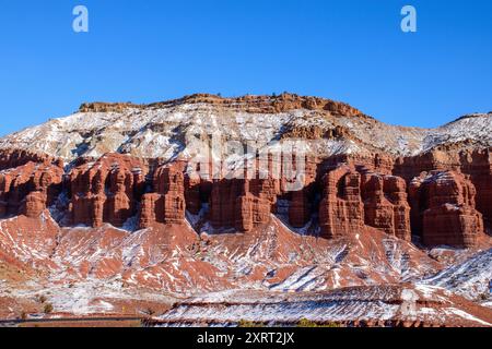 Vue panoramique hivernale sur les formations rocheuses rouges poussiéreuses de neige dans le parc national de Capitol Reef, Utah. Un contraste majestueux de la neige blanche avec des falaises rouges. Banque D'Images