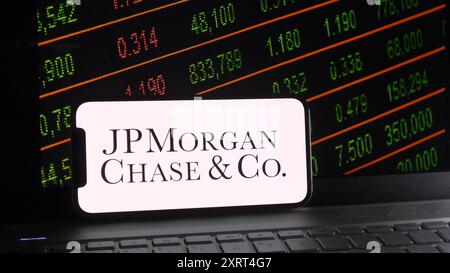 Chine. 12 août 2024. Dans cette illustration photo, le logo de JPMorgan Chase & Co est affiché sur un smartphone avec une bourse et un fond de clavier d'ordinateur portable. Crédit : SOPA images Limited/Alamy Live News Banque D'Images