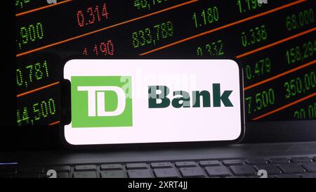 Chine. 12 août 2024. Dans cette illustration photo, le logo de la Banque Toronto-Dominion est affiché sur un téléphone intelligent avec une bourse et un fond de clavier d'ordinateur portable. Crédit : SOPA images Limited/Alamy Live News Banque D'Images