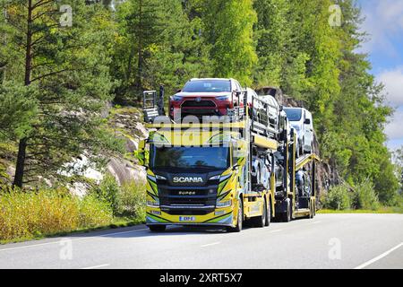 Magnifiquement personnalisé le camion porte-véhicule jaune Scania P500 transporte des voitures sur la route 52 un jour d'automne. Salo, Finlande. 7 septembre 2023. Banque D'Images