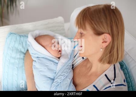 Grand-mère tenant un nouveau-né. Grand-mère rencontrant un nouveau membre de la famille. Mère avec enfant endormi. Banque D'Images