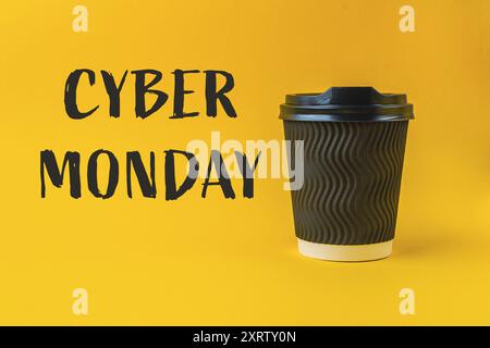 Une tasse à café avec un couvercle noir se trouve sur un fond jaune avec les mots Cyber Monday écrits en dessous Banque D'Images