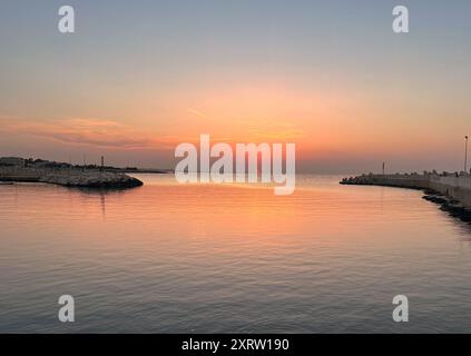 Un coucher de soleil magnifique dans l'embouchure du port de pêche de Giovinazzo sur les étés calmes chauds soir Banque D'Images