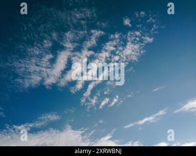 Le ciel est bleu avec quelques nuages éparpillés. Les nuages sont blancs et moelleux, donnant au ciel une sensation de lumière et d'air Banque D'Images