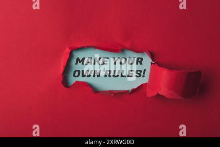 Un fond rouge avec un mot bleu qui dit faire vos propres règles. Le mot « rules » est écrit en noir Banque D'Images