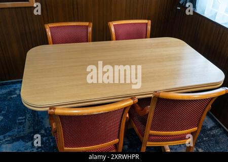 Un cadre confortable avec une table en bois et quatre chaises. Banque D'Images