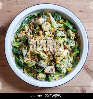 Un plat de légumes frais carbonisés avec choux de bruxelles, fromage grillé, tiges de brocoli, maïs doux, noix écrasées etvinaigrette. Banque D'Images