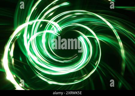 Vague spiralée verte brillante. Beaux tourbillons, vortex coloré. Fond de néon abstrait avec des lignes brillantes ondulées Swirl Banque D'Images