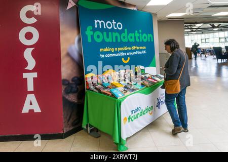 Femme regardant une librairie d'occasion pour Moto Foundation Charity aux services de Blyth sur l'autoroute A1(M). Banque D'Images