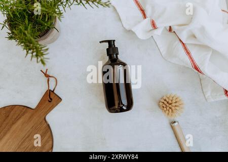 Maquette de bouteille marron pour de détergent à vaisselle naturel dans la cuisine. Divers articles et ingrédients pour la maison écologique. Vue de dessus Banque D'Images