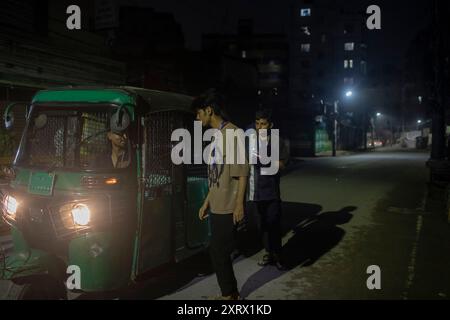 Dhaka, Bangladesh. 12 août 2024. Un étudiant vérifie une voiture gnc la nuit lors d'une patrouille communautaire dans son quartier en l'absence de forces de l'ordre. Des volontaires patrouillent dans les quartiers en l'absence de forces de police bangladaises, pendant la nuit à Dhaka. Le lauréat du prix Nobel Muhammad Yunus et son gouvernement intérimaire nouvellement nommé se sont mis en route le 9 août pour rétablir « la loi et l'ordre » après un soulèvement mené par des étudiants et des manifestations de masse meurtrières qui ont forcé son prédécesseur Hasina à l'exil. Crédit : SOPA images Limited/Alamy Live News Banque D'Images