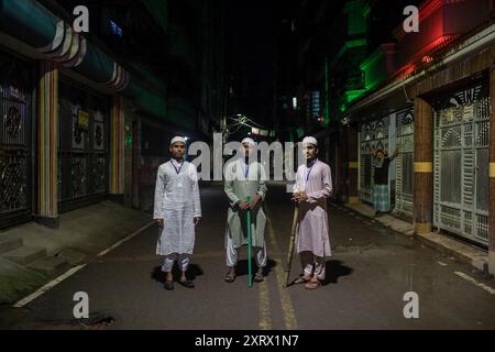 Dhaka, Bangladesh. 12 août 2024. Un groupe d'étudiants de la Madrasa posent pour une photo lors d'une patrouille communautaire la nuit dans leurs quartiers en l'absence de forces de l'ordre. Des volontaires patrouillent dans les quartiers en l'absence de forces de police bangladaises, pendant la nuit à Dhaka. Le lauréat du prix Nobel Muhammad Yunus et son gouvernement intérimaire nouvellement nommé se sont mis en route le 9 août pour rétablir « la loi et l'ordre » après un soulèvement mené par des étudiants et des manifestations de masse meurtrières qui ont forcé son prédécesseur Hasina à l'exil. Crédit : SOPA images Limited/Alamy Live News Banque D'Images