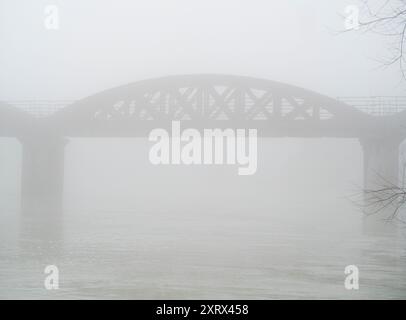 Une partie pittoresque de la Tamise qui rejoint Hinksey Stream à Kennington. Ceci fait partie du Thames Path, et la scène est dominée par ce pont ferroviaire abandonné. Ici, il semble étrange et mystérieux dans un épais brouillard hivernal. Banque D'Images